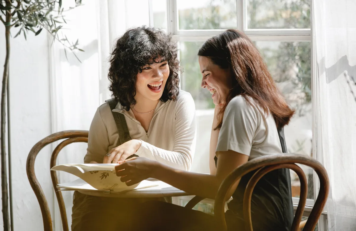 Beyond the Book: two colleagues talking over paperwork in warm natural light.