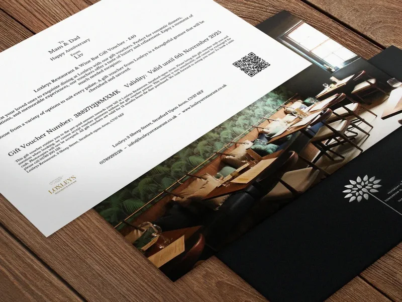 Loxleys gift voucher and gift packaging showing the refreshed identity and gold feather motif.