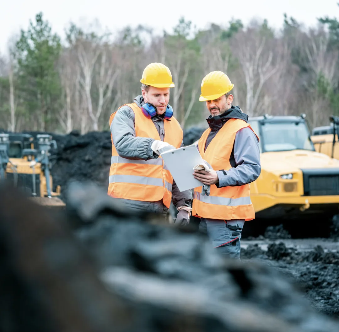 PlantFix UK engineers in hi-vis and hard hats reviewing a job on site.